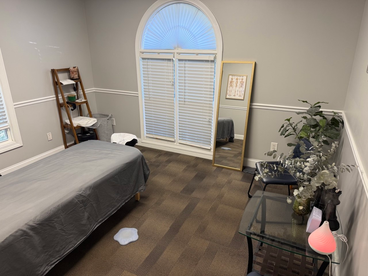 Arched window, plants and massage table in the studio