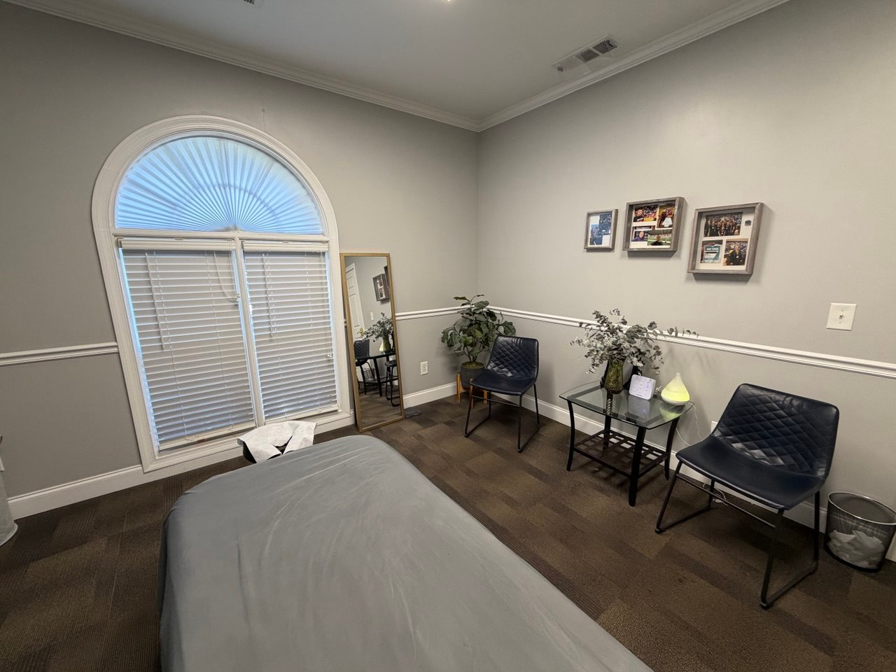 Mykola’s treatment room with a massage table, arched window and seating area